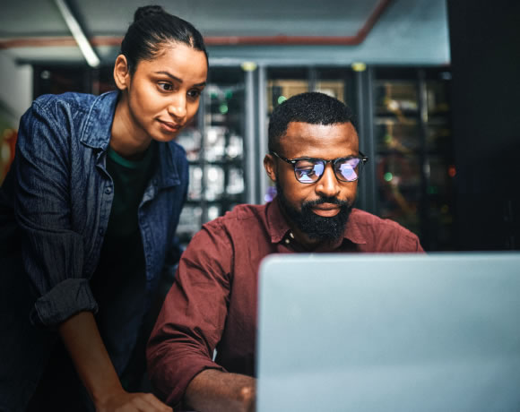 Two students working on a laptop